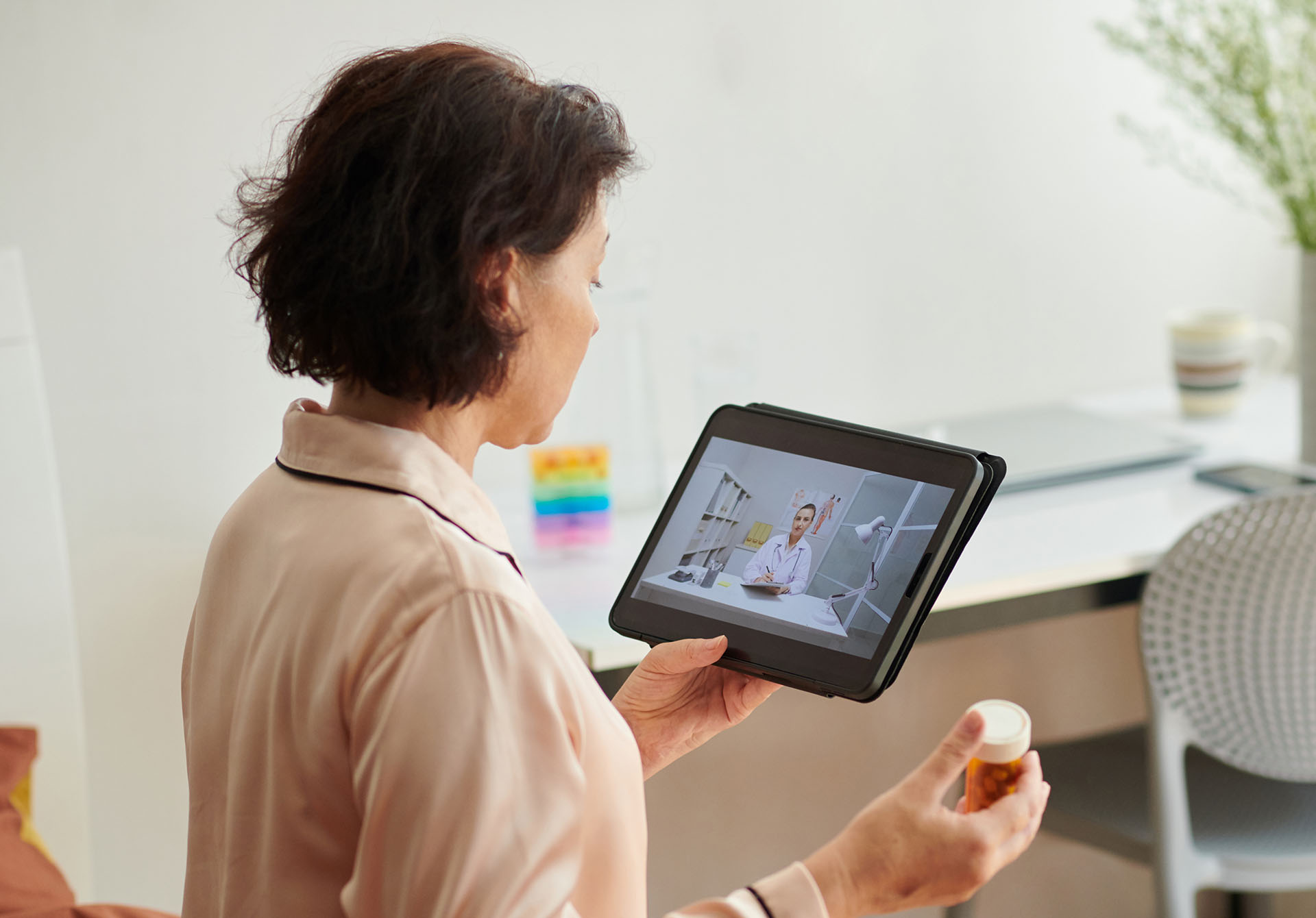 Sick woman video calling doctor before taking medicine